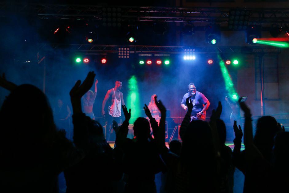 Crowd enjoying live music and dancing at a vibrant nightclub concert.