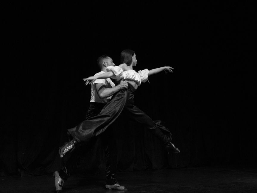 A black and white image depicting a graceful dance performance with two dancers.