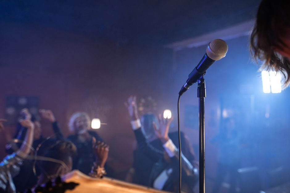 A lively nightclub scene with a crowd dancing and a microphone on stage.